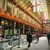 Interior view of a historic market featuring flags and people walking through. - Olive Oil Times