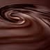 Smooth, swirling texture of dark chocolate with a glossy finish. - Olive Oil Times
