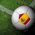 A soccer ball featuring the Spanish flag design on a grass field. - Olive Oil Times