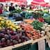 Display of fresh vegetables and fruits including beets, carrots, and lemons at a market stall. - Olive Oil Times