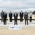Group photo of G7 leaders standing on a stage at a beach in Cornwall. - Olive Oil Times