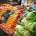 A colorful display of fresh vegetables and fruits including lettuce, tomatoes, and peppers at a market. - Olive Oil Times