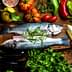 Two whole fish placed on a wooden board surrounded by various vegetables and herbs. - Olive Oil Times