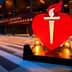 Large red heart symbol with a torch in front of a convention center entrance. - Olive Oil Times