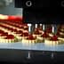 Automated machine dispensing red filling onto cookie bases in a production line. - Olive Oil Times