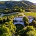 Aerial view of Chateau d'Estoublon surrounded by vineyards and trees. - Olive Oil Times
