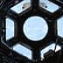 Interior view of the International Space Station's Cupola with a circular window showing Earth. - Olive Oil Times