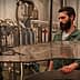 A man with a beard overseeing machinery in an oil production facility. - Olive Oil Times