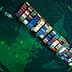 Aerial view of a large container ship loaded with colorful cargo containers on the water. - Olive Oil Times