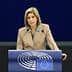 A woman speaking at a podium with the European Parliament logo during a session. - Olive Oil Times