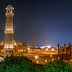 Badshahi Mosque illuminated at night with minarets and domes visible. - Olive Oil Times