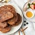 A plate of fried cinnamon French toast served with honey, berries, and a sprig of mint. - Olive Oil Times