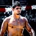Shirtless male athlete with short dark hair standing outdoors, looking to the side. - Olive Oil Times