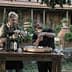 Two men participating in an olive oil tasting session at a wooden table outdoors. - Olive Oil Times