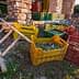 Various colorful crates filled with harvested olives placed near a stone structure. - Olive Oil Times