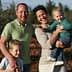 A family of four posing together in an olive grove, with two children and two adults smiling at the camera. - Olive Oil Times