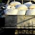 Pickup truck with a bed full of white bags on a street. - Olive Oil Times