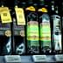 Various bottles of olive oil displayed on a store shelf with labels and pricing information. - Olive Oil Times