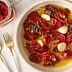 Bowl of marinated sun-dried tomatoes with garlic and herbs in olive oil. - Olive Oil Times