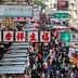 A busy street market in Hong Kong filled with numerous stalls and a large crowd of people. - Olive Oil Times