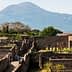 Ancient ruins of Pompeii with Mount Vesuvius visible in the background under clear skies. - Olive Oil Times