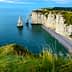 Cliffs and a prominent rock formation in the sea at Etretat, France, under a clear blue sky. - Olive Oil Times
