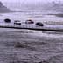 Vehicles cross over a flood control basin on Sunday, Aug. 20, 2023, in Palm Desert, Calif.