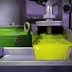 Stream of fresh olive oil flowing from a processing machine in a production facility. - Olive Oil Times