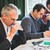 Three men participating in a tasting session, focusing on their individual tasks and using tasting tools. - Olive Oil Times