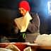 A woman wearing a red headscarf is preparing dough in a kitchen setting. - Olive Oil Times