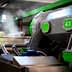 Industrial olive oil processing machine with green accents and steam emerging from the equipment. - Olive Oil Times