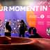 Colorful exhibition display featuring the phrase 'Our Moment in Time' and various images on the wall. - Olive Oil Times