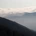 Layered mountain landscape with fog and clouds obscuring the peaks in the background. - Olive Oil Times