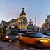 Buses and taxis moving through a busy street in Madrid during sunset. - Olive Oil Times