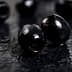 Close-up of black olives placed on a dark textured surface. - Olive Oil Times