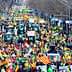 A large crowd of demonstrators with tractors and flags participating in a protest. - Olive Oil Times