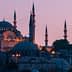 A view of a mosque in Istanbul with multiple minarets during dusk, illuminated by soft lighting. - Olive Oil Times