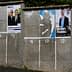 Various political campaign posters displayed on a concrete wall with numbered sections. - Olive Oil Times