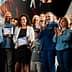Group of people at an award ceremony, some holding certificates and applauding. - Olive Oil Times