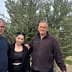 Three individuals standing together in front of an olive tree in an outdoor setting. - Olive Oil Times