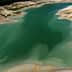 Aerial view of a calm water body with varying shades of green and blue. - Olive Oil Times
