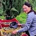 Woman sorting olives in red and yellow baskets in an outdoor setting. - Olive Oil Times