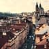 Aerial view of Prague showcasing rooftops and St. Nicholas Church in the background. - Olive Oil Times