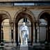White statue of a historical figure located in the courtyard of the College de France building. - Olive Oil Times