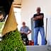 Four men observing the process of olive extraction in an indoor setting. - Olive Oil Times