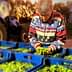 Individual sorting green olives in blue baskets on a farm with a tractor in the background. - Olive Oil Times