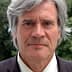 Close-up portrait of a man with gray hair wearing a suit and a neutral expression. - Olive Oil Times