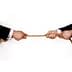 Deux mains en costume d'affaires saisissant une corde par les extrémités opposées, engagées dans un tir à la corde. - Olive Oil Times