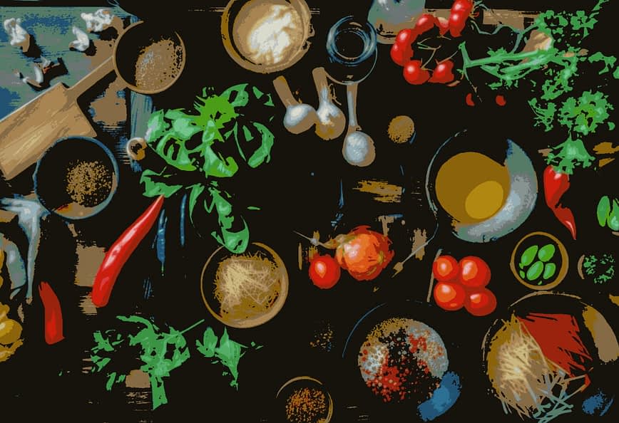 An overhead view of various cooking ingredients including vegetables, herbs, and spices on a wooden surface. - Olive Oil Times