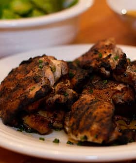 ψητοί μηροί κοτόπουλου σε ένα πιάτο καρυκευμένο με λεμόνι και ελαιόλαδο